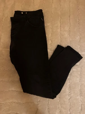 Svarta replay jeans - Säljer ett par svarta replay jeans i modellen pilar. Något större i storleken vid midjan. Mycket bra skick och snygg färg.