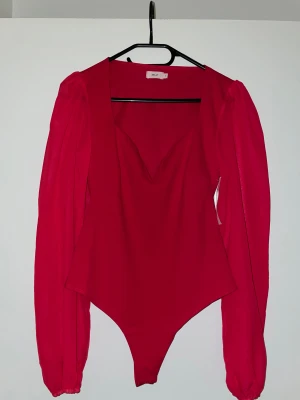 Röd body med puffärm från Nelly - Body från Nelly, storlek S men för kort på mig som är 1,72cm lång. Helt ny med prislapp.