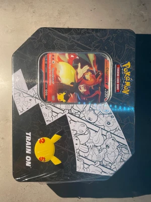 Lance’s Charizard V Big Tin Celebrations - Säljer en oöppnad celebrations tin från 2021! OBS (säljes inte längre) Den innehåller 6st celebrations booster packs plus 2st random booster packs! Sen får man ju inte glömma Lance’s charizard som man även får. Perfekt som julklapp till exempel eller bara spara i några år så lär den gå upp i värde :)
