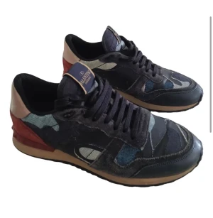 Valentino Rockrunner  - Snygga Valentino Garavani Rockrunner sneakers med camouflagemönster i blått, svart och grått. Skorna har detaljer i mocka och skinn, beige sula och röda samt champagnefärgade partier vid hälen. Mycket bra skick 