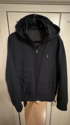 Svart pufferjacka från Polo Ralph Lauren - Snygg svart pufferjacka från Polo Ralph Lauren med huva och dragkedja framtill. Nypris runt 4 tusen, passar bra på mig som är ish 180