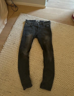 Slim fit Jeans - Snygga mörkgrå Scotch and soda jeans i slim fit med klassisk femficksdesign. Jeansen har en något tvättad look och är tillverkade i bomull med lite stretch för extra komfort. Perfekta för dig som gillar en smalare passform och stilren look.                                                                                                  Bara att skriva om nu har funderingar!                  Kan gå ner i pris vid snabb affär