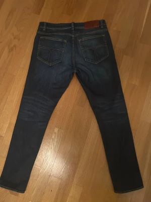 Mörkblå jeans Evolve 30/30 - Snygga mörkblå jeans från Evolve i klassisk femficksmodell med kontrastsömmar och läderpatch bak. Jeansen  är tillverkade i slitstarkt bomullsmaterial. Perfekt för dig som gillar stilrena och tidlösa jeans. Kontakta vid eventuella frågor!😁
