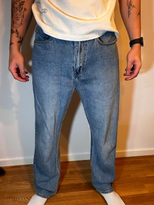 Blå jeans med A-emblem, loose fit Abrand Jeans - Säljer ett par ljusblå jeans med loose passform och raka ben. Byxorna har klassiska fem fickor och ett svart A-emblem på bakfickan. Jeansen är tillverkade i denim och har en avslappnad stil som passar perfekt till sneakers och t-shirt.