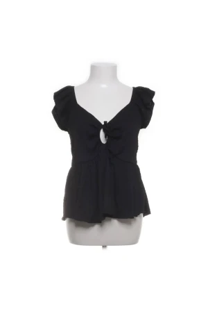Svart blus  - Supersöt svart blus med v-ringning och knyt framtill som skapar en liten öppning. Blusen har korta volangärmar. 