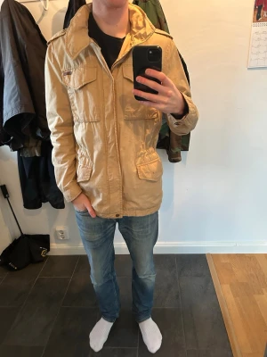 Beige fieldjacket - En as fett beige fieldjacket i fint skick från Peak Performance 
