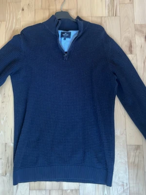 Marinblå stickad tröja från Park Lane - Snygg marinblå stickad tröja från Park Lane med half zip och ribbade muddar. Tröjan har ett diskret rutmönster och långärmad design, perfekt för kyliga dagar. Passar dig som gillar klassisk stil med en modern twist.  tröjan är mörkblå*