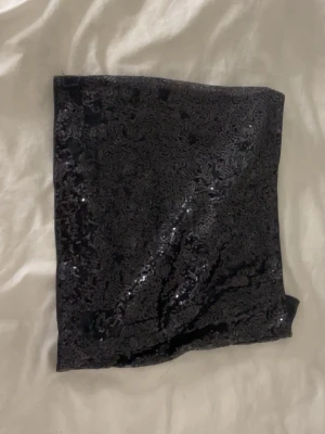 Svart paljettkjol - Säljer en svart kortkjol täckt med glittriga paljettet kjolen har en rak och tight passform som ger en snygg och festlig look. Perfekt för dig som vill sticka ut och glänsa lite extra och passar för födelsedagar + nyår + gäähhhdddaaaaa