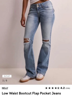 Bootcut jeans med låg midja från Nelly - Snygga ljusblå bootcut jeans från Nelly med låg midja och slitna detaljer vid knäna. Jeansen har klassiska fem fickor, varav bakfickorna har lock och knapp. knappt använda! ordpris 699kr