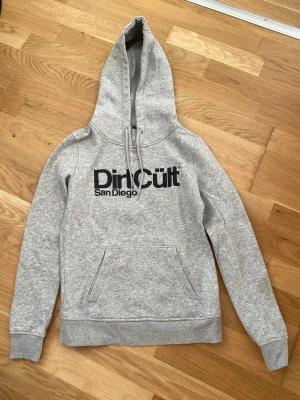 Grå DirtCült hoodie - Grå dirtcült hoodie som inte kommer till användning längre. Bra skick. S sitter som XS