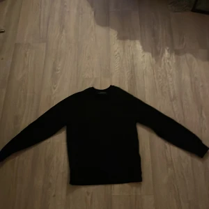 Svart tröja från Peak Performance - Svart långärmad tröja från Peak Performance i enkel och stilren design. Rund halsringning och normal passform, perfekt för dig som gillar klassiska och snygga plagg. Materialet känns mjukt och bekvämt mot huden.