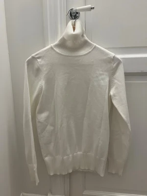 Vit polotröja från Saint Tropez - Säljer en stilren vit polotröja från Saint Tropez i storlek S. Tröjan har ribbad hög krage och muddar vid ärmslut och nederkant. 