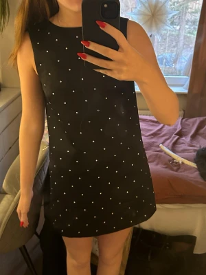 Svart klänning - Svart klänning med rosett i ryggen och stenar. Passar perfekt till nyår!!🤩Helt ny och oanvänd med prislapp😊🩷