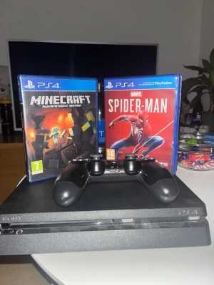 PlayStation 4 med Minecraft och Spider-Man - Säljer en PlayStation 4 med en originalkontroll och två populära spel: Minecraft och Marvel's Spider-Man. Konsolen är i gott skick med mindre yttre slitage, fungerar utmärkt för gaming och underhållning. Perfekt för både barn och vuxna som vill spela direkt!