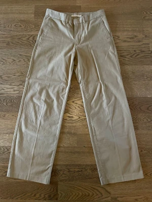 Levis Chinos - Levis "Baggy Trousers" Chinos. Klassisk chinos-beige, i storlek 27. Sparsamt använda, i jättefint skick. Säljs pga minskad användning. Bara att höra av dig vid intresse, frågor eller önskan om fler bilder!