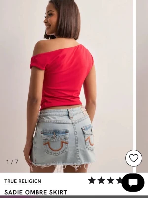 True Religion Sadie mini skirt flap - Säljer min True Religion kjol. Den är i mycket bra skick och bara använt ett fåtal gånger, säljer pga att den inte passar mig längre. Det är en kort jeanskjol, fransar längst ned och  otroligt fina fickor med ombre i gult och orange. Perfekt för sommaren!🎀 Nypris 1099 kr