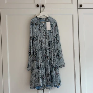 Blommig kortklänning Zadig & Voltaire - Supersöt ljusblå kortklänning från Zadig & Voltaire med blommigt mönster och fjärilar. Klänningen har prislappen kvar och är aldrig använd. 