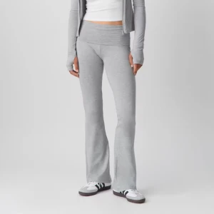 Grå bootcut mjukisbyxor - Snygga grå mjukisbyxor med bootcut och hög midja. Byxorna är tillverkade i mjukt och stretchigt material som sitter skönt mot kroppen. Perfekt för chill dagar eller när du vill ha en avslappnad look. Enkel design utan fickor eller synliga detaljer.