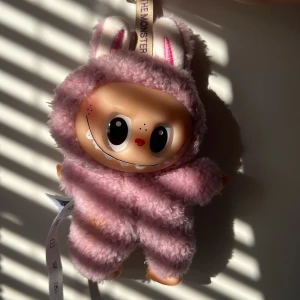 Söta labubus  - Två gulliga handväskor från Pop Mart, formade som små monster i kanindräkt. En är ljusrosa och den andra mintgrön, båda med stora ögon och lurvigt plyschmaterial. Perfekt accessoar för dig som gillar unika och lekfulla detaljer.