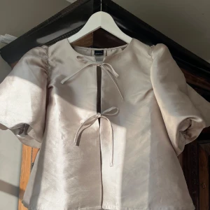 Jättefin blus från Gina Tricot!  - Jättefin blus från Gina Tricot. Champangefärgad i mycket bra skick!💕Två rosetter framtill som man kan knyta o puffiga ärmar 