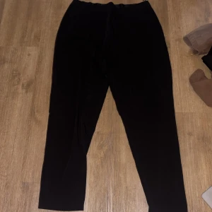 Svarta byxor från Object, storlek 40 - Svarta byxor från Object i storlek 40. De har en enkel och stilren design med resår i midjan för extra komfort. Byxorna är raka i modellen och passar perfekt till en avslappnad men ändå snygg look.