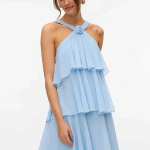 Ljusblå volangklänning med öppen rygg från Vero Moda🩵 - Supersöt ljusblå kortklänning med flera lager volanger och snygg halterneck med rosdetalj framtill🌹. Klänningen har öppen rygg med breda axelband och dragkedja bak. 😇 har ett litet märke från mitt läppstift men syns inte eftersom de bara är på volangen💕det ser ut som en större fläck pga bladen från blommorna i bakgrunden☺️