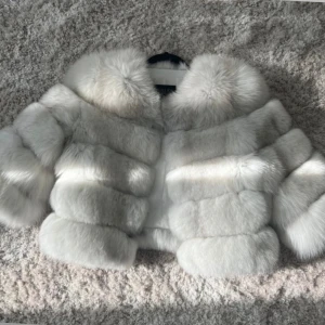 Vit pälsjacka med fluffig krage - Supermjuk och lyxig vit pälsjacka 🤍. Jackan är croppad och har en riktigt statement-look som drar blickarna till sig. Perfekt för dig som vill sticka ut och hålla dig varm med stil. 