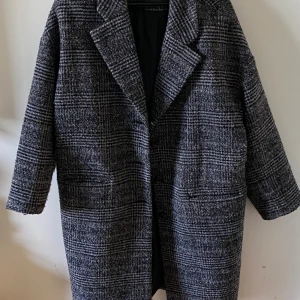 Kappa Levi's - Säljer en oversized rutig kappa från Levi's i svart och grått. Kappan har klassisk krage, stora knappar framtill och två djupa fickor. Storlek XS (oversized så passar mer S-M). Knappt använd! 
