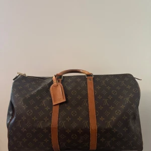 Louis Vuitton vintage keepall - Väldigt fin vintage Louis Vuitton keepall väskan är i fint skick och har tecken på lite användning som syns på bilderna annars är väskan i grymt vintage skick, storleken är 50 och den är fin i canvas och i handtagen. Samt inga fläckar inuti väskan eller dålig lukt! Vid frågor så tveka inte på och höra av dig.