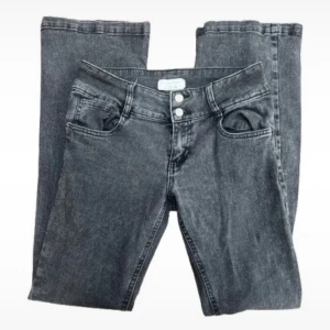 Grå bootcut jeans med dubbla knappar - Lågmidjade mörkgråa jeans som är köpta i Italien Står att de är Stl 38 men skulle snarare säga att de är som xs Midjemått- mellan 70-72 cm Innerbenslängd- ca 74cm  I mycket fint skick