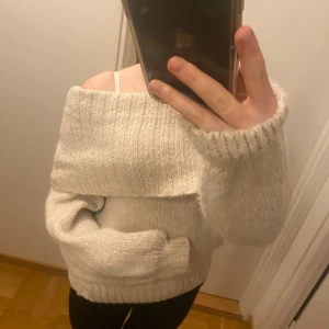 Beige offshoulder stickad tröja - Supermysig beige stickad tröja med bred ribbad offshoulder-tröja. Materialet är väldigt skönt och inte stickig alls. Väldigt fin och mysig när det blir lite kallare. Helt oanvänd.