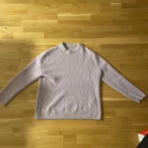 Ljuslila stickad tröja från Zara - Mysig ljuslila stickad tröja från Zara med ribbad struktur och rundad hals. Tröjan har långärmade ärmar och en enkel, clean look som är lätt att matcha med jeans eller kjol. Perfekt för dig som gillar softa färger och chill vibes.