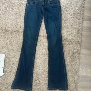 Bootcut Jeans - Snygga blå bootcut jeans från Tom Tailor, modell Alexa. Materialet är mjukt denim med kontrastsömmar och lätt utsvängda ben. Det är en knapp på baksidan som saknas men annars är de i super bra skick! 🫶🥳