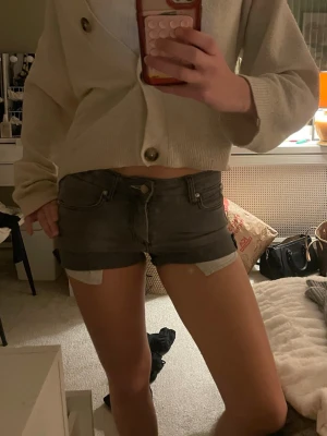 Grå jeansshorts från Acne Jeans - Säljer ett par gråa lågmidjade shorts från acne. Om fickorna ska synas eller inte kan man själv justera efter preferens🤗