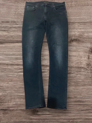 Svarta Nudie jeans  - Snygga svarta jeans i stretch som sitter jättefint! Lite slitningar som gör dem extra snygga. Normala i midjan och raka/slim i benen = funkar till allt. I superbra skick, inga hål eller fläckar.  Storlek: (31/32) Märke: (Nudie) Skick: Mycket bra  Perfekta både till vardag och utgång — bara att styla med några sköna GATs✨