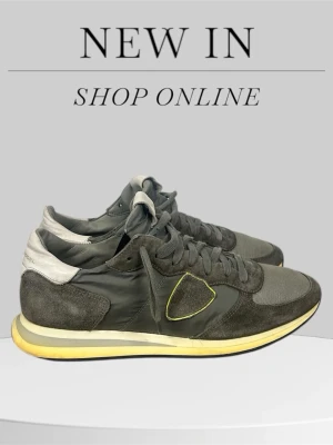 Grå Philippe Model sneakers med gul sula - Snygga sneakers från Philippe Model i olika nyanser av grått med detaljer i mocka och mesh. Skorna har snörning, vit och gul sula samt en ikonisk sköld på sidan med gul kant. Perfekt för dig som gillar stilrena och sportiga skor.