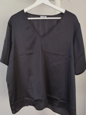 Svart blus från Bubbleroom x Alexandra Nilsson - Säljer en svart, luftig blus i storlek XXL från Bubbleroom x Alexandra Nilsson. Blusen har v-ringning, korta ärmar och är tillverkad i ett tunt, lätt material som ger en snygg och avslappnad look. Använd endats en gång.