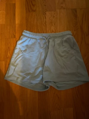 Ljusblåa shorts från H&M  - Säljer ett par ljusblåa shorts från H&M i storlek XS. De har elastisk midja med snörning och är gjorda i mjuk bomulls- och polyesterblandning. Perfekta för chill dagar. Har fickor på sidorna🤗