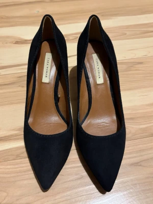 Svarta mockaklackar från Zara - Snygga svarta klackar i mocka från Zara  med spetsig tå och låg klack. Klassisk och stilren design med brunt innerfoder och elegant siluett. Har använt de typ 3 gånger.