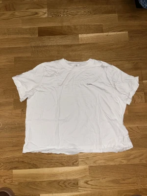 Vit basic t-shirt från H&M Divided - Enkel vit t-shirt från H&M Divided med rund hals och korta ärmar. Tillverkad i mjuk bomull och har en clean look utan mönster eller tryck, perfekt till alla outfits. Klassisk passform och skön att bära hela dagen.