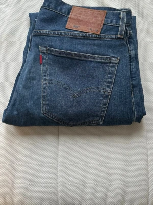 Levi's 501 blå jeans W31 L32 - Klassiska blå Levi's 501 jeans med rak passform och normal midja. Jeansen har fem fickor, knappgylf och den ikoniska läderpatchen bak i midjan. Köpta 2022/2023 så relativt använda men dom har inte tappat passformen utan är riktigt fina! 