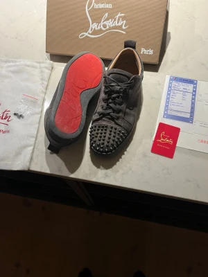 Christian louboutin - Säljer ett par riktigt snygg skor från Christian Louboutin i grått. Använda hyfsat mycket, säljer dom lite billigare för att dom är lite sönder i hälen. Du får kvitto box o allt med dig, du får även extra nitar med. 