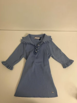 Festlig stickad blus - Festlig åtsittande blus med små volanger till ärmarna. Mycket bra skick. 