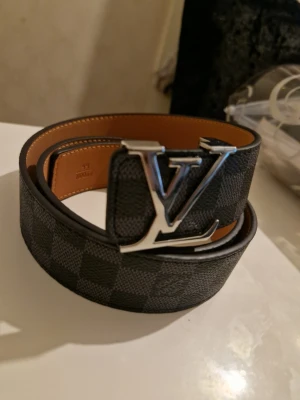 Svart rutig bälte - Svart rutig bälte i mycket gott skick, längd 110cm, pris kan diskuteras