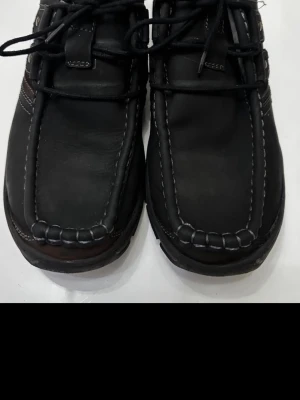 Lasocki svarta och bruna skinnkängor - Säljer ett par stilrena kängor från Lasocki i svart och mörkbrunt skinn. Skorna har kraftig snörning, kontrastsömmar och robust sula. Perfekta för dig som vill ha en klassisk men ändå modern look. Märket syns tydligt på innersulan.