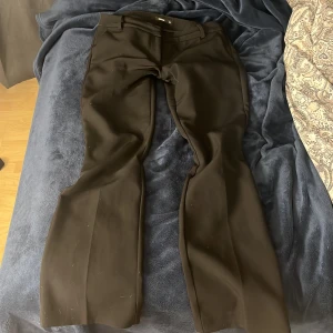 Svarta bootcut kostymbyxor BikBok - Svarta kostymbyxor från BikBok i storlek 38. Byxorna har bootcut-snitt med vida ben och låg midja. Super snygga. 