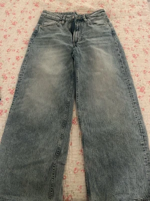 Blå croppade wide jeans från H&M - Säljer ett par blå jeans från Hm i storlek 36. De har hög midja, croppad längd och breda ben för en riktigt chill vibe. Klassisk femficksmodell med dragkedja och knapp. Perfekta till sneakers eller boots. Köpte dom för 400 kr och tog jag tog aldrig på mig jeansen 