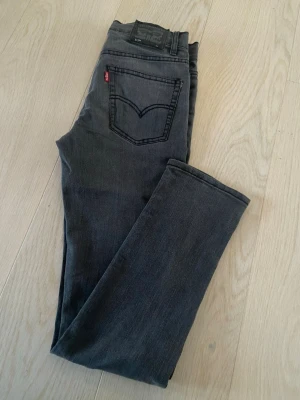 Levis 512 mörkgrå jeans - Snygga mörkgrå Levis 512 jeans med klassisk femficksdesign och röd Levis-tag på bakfickan. Jeansen har rak passform och är tillverkade i mjukt jeansmaterial som sitter skönt hela dagen. 