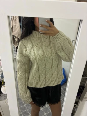 Beige stickad tröja från NA-KD - Supermysig beige stickad tröja med grovt kabelmönster och hög krage. Tröjan har lång ärm och en loose fit som ger en chill vibe. 