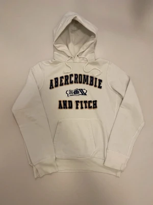 Vit vintage Abercrombie & fitch hoodie M - Vit vintage Abercrombie and fitch hoodie //  Storlek M //  Mycket bra skick endast en liten fläck som syns på sista bilden men går enkelt bort i tvätten💯  Skriv vid minsta fråga eller fundering🤝